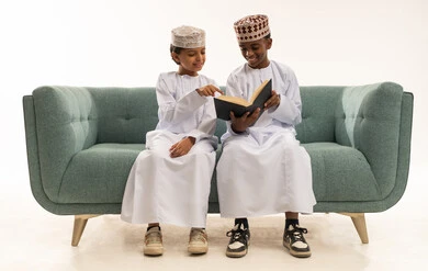 Omani Boys Wearing Traditional Clothes Reading Book