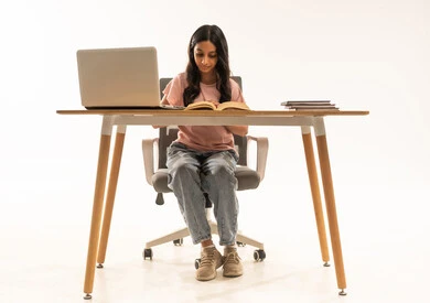Saudi Woman Student Reading at Desk with Laptop