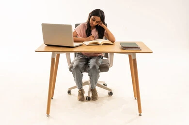 فتاة سعودية تدرس مع كمبيوتر محمول بخلفية بيضاء