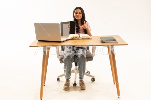 Arab Girl Student at Desk Holding Smartphone