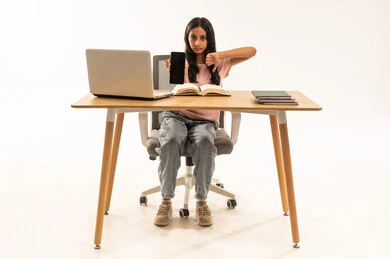 فتاة عربية طالبة تشير بعدم الإعجاب مع هاتف ذكي