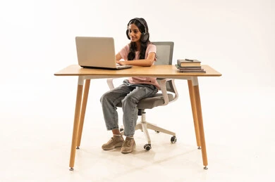 Young Girl with Laptop and Headphones at Desk