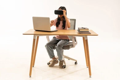 Girl Using VR Headset and Laptop at Desk