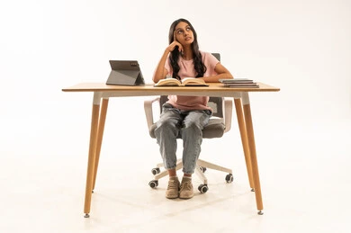 فتاة سعودية تفكر أثناء الدراسة على المكتب