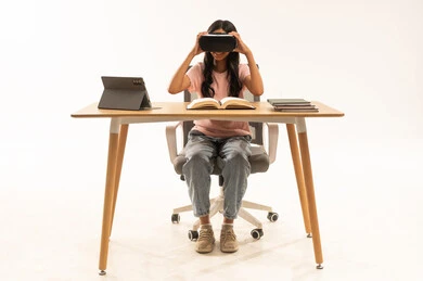 طالبة هندية تستخدم نظارة الواقع الافتراضي على المكتب طالبة هندية تستخدم نظارة الواقع الافتراضي على المكتب