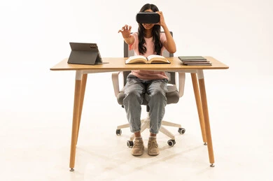 فتاة عربية تستخدم نظارة الواقع الافتراضي على المكتب