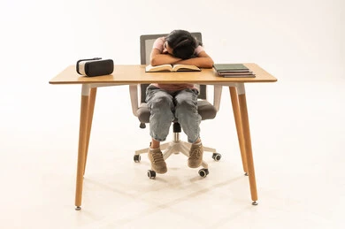 طفلة عربية نائمة على المكتب مع كتب ونظارة واقع افتراضي