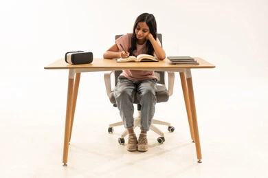 فتاة عربية تدرس على مكتب مع نظارة واقع افتراضي