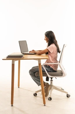 فتاة سعودية تستخدم حاسوباً محمولاً خلف مكتب