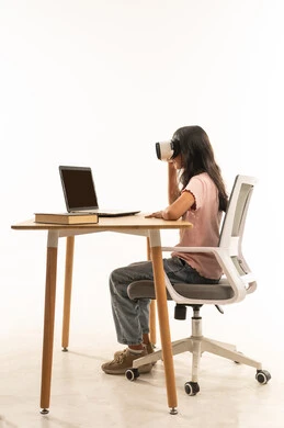 Arab Girl Using VR Headset at Desk with Laptop
