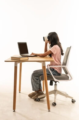 طفلة عربية تستخدم نظارة الواقع الافتراضي والحاسوب المحمول