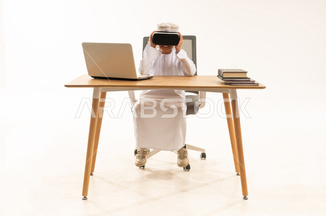 Omani Boy Using VR Headset at Laptop Desk