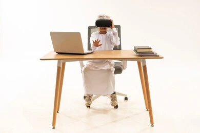 Emirati Boy with VR Headset and Laptop at Desk
