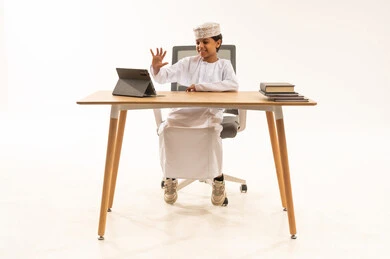 طفل عماني يلوح لجهاز لوحي في استوديو