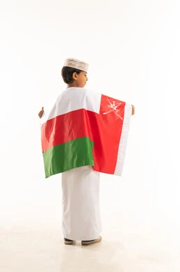 Omani Boy in Traditional Dress Holding National Flag