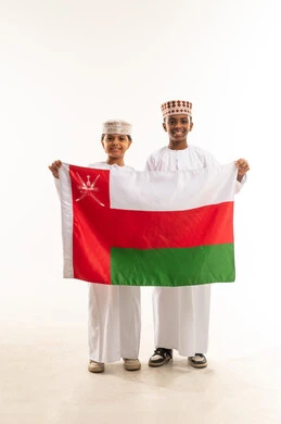 Omani Children Holding National Flag in Traditional Dress