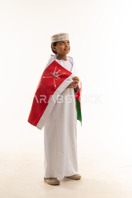 طفل عماني بالعلم الوطني والزي التقليدي