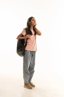 طالبة عربية بسماعات رأس وحقيبة ظهر في الاستوديو