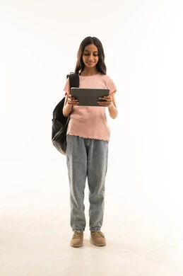 طالبة سعودية شابة تمسك بجهاز لوحي بخلفية بيضاء