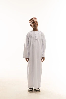 طفل عماني بالزي التقليدي أمام خلفية بيضاء