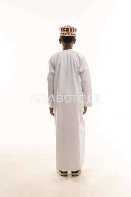 Omani Boy in Traditional Dishdasha Standing Back View