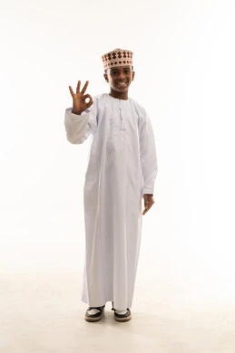 طفل عماني بالزي التقليدي يشير بعلامة الموافقة