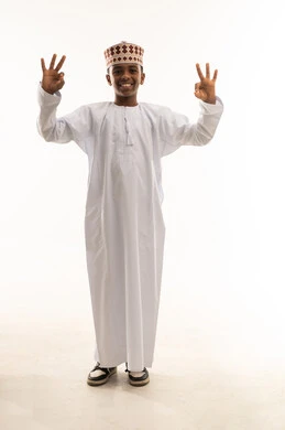 Omani Boy in Traditional Dishdasha Making Okay Gesture