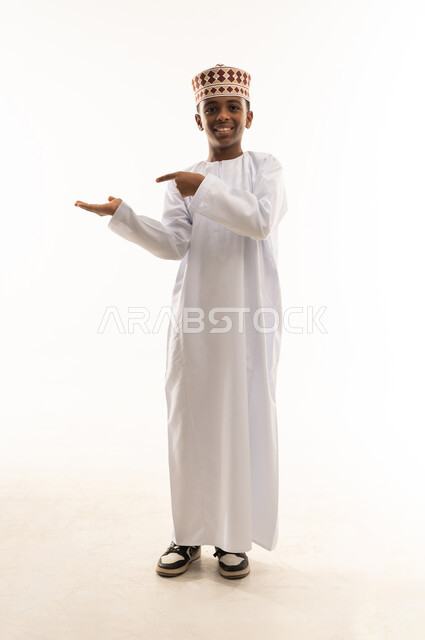 Omani Boy in Traditional Dishdasha Presenting Gesture