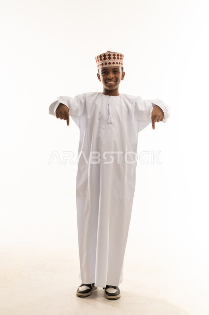 Omani Boy in Traditional Dishdasha Pointing Down