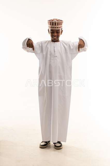 Omani Boy in Traditional Dress Pointing Down