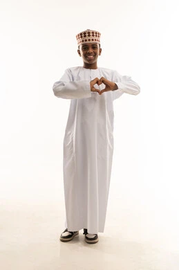 Omani Boy in Traditional Dishdasha Making Heart Gesture