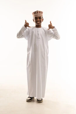 Omani Boy in Traditional Dishdasha with Hand Gesture Omani Boy in Traditional Dishdasha with Hand Gesture