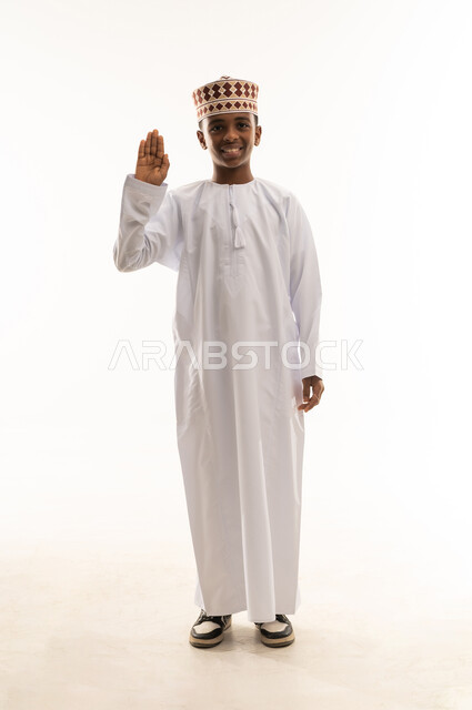 ولد عماني بالزي التقليدي يلقي التحية بخلفية بيضاء