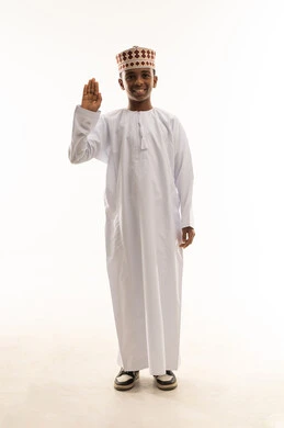 ولد عماني بالزي التقليدي يلقي التحية بخلفية بيضاء