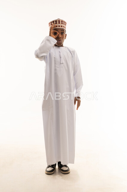 Omani Boy in Traditional Dress with Hand Gesture