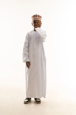 طفل عماني بالدشداشة التقليدية والكمة على خلفية بيضاء