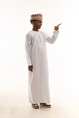 طفل عماني بالزي التقليدي يشير في استوديو