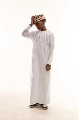 Omani Child in Traditional Dishdasha and Kumma