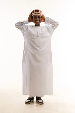 طفل عماني بالدشداشة والكمة العمانية التقليدية