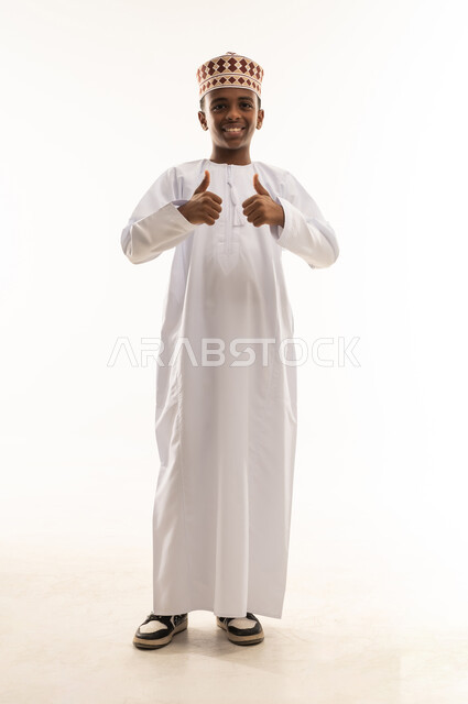 صبي عماني بالزي التقليدي يرفع إبهامه للتأييد