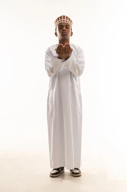 ولد عماني بالزي التقليدي في وضعية الدعاء