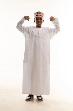 طفل عماني بالزي التقليدي يستعرض عضلاته