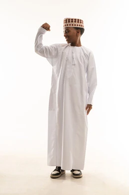 طفل عماني بالزي التقليدي يستعرض عضلاته