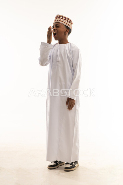 Omani Boy Yawning in Traditional Dishdasha and Kummah