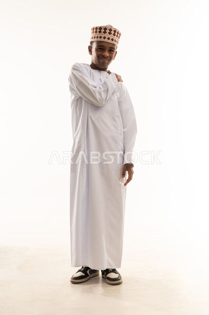 ولد عماني بالدشداشة التقليدية والكمة في الاستوديو