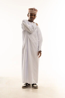 ولد عماني بالدشداشة التقليدية والكمة في الاستوديو