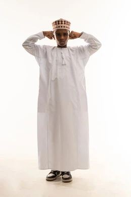 Omani Child in Traditional Dishdasha Flexing Muscles