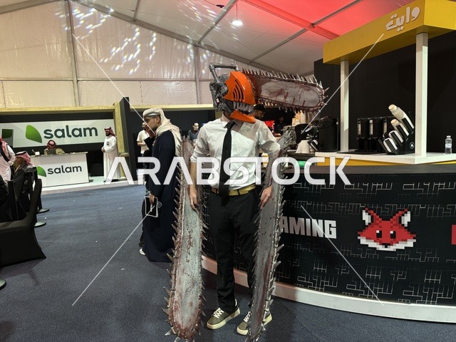 رجل يرتدي زي لعبة تنكري في فعالية جيمينق بلس (+) في جامعة الملك فهد للبترول والمعادن بالظهران، المنطقة الشرقية، المملكة العربية السعودية، يوم 28 من يناير 2026، تجربة ترفيهية رقمية مخصصة لعشّاق الألعاب الإلكترونية، مسابقات وتحديات ألعاب، أجهزة وتقنيات حديثة، مشاركة شبابية واسعة، أجواء حماسية تجمع بين الترفيه والتقنية.