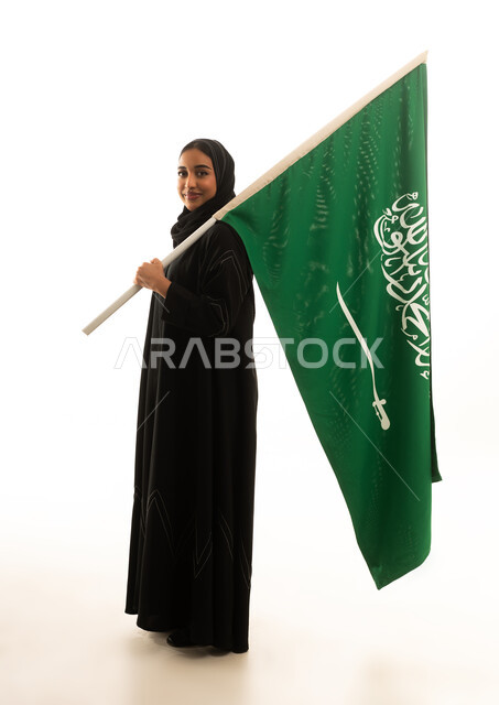 امرأة سعودية تحمل العلم الوطني على خلفية بيضاء