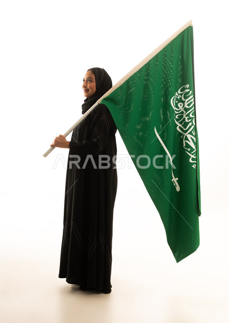 امرأة سعودية بالعباءة تحمل علم السعودية خلفية بيضاء